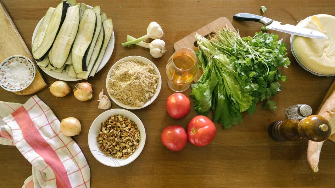 Top view of fresh vegetables and ingredients on a wooden table, ideal for healthy recipes.